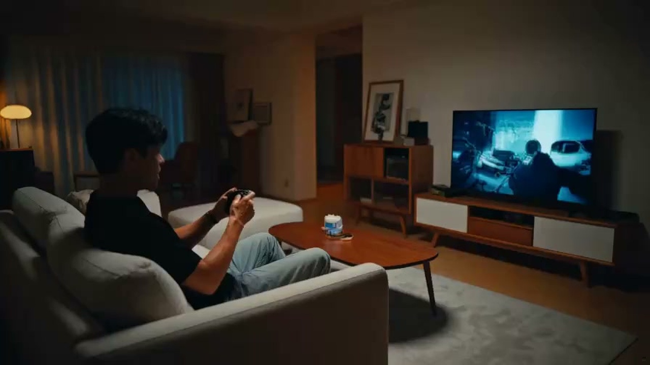 コントローラーを手に持って最新アクションゲームの発表に興奮するゲーマーの写真