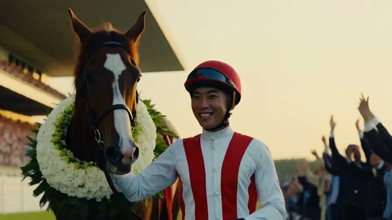 表彰式で歓喜の花輪をかけた競走馬の隣で誇らしげに並ぶ調教師とジョッキーのリアル写真