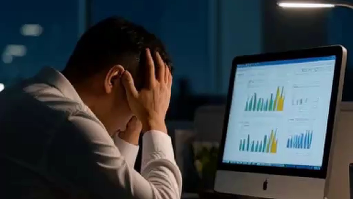 深夜のオフィスで頭を抱え激しい疲労とストレスに限界を迎える会社員